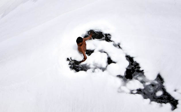 New Delhi, India: A boy searches for coins in the polluted waters of the Yamuna river