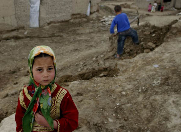 Kabul, Afghanistan: A refugee girl outside her temporary home