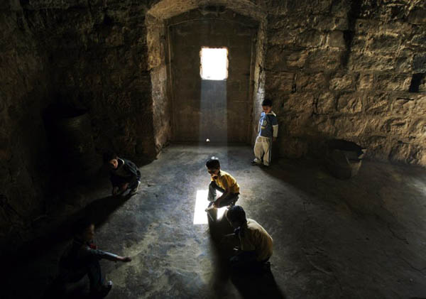 Ramallah, West Bank: Boys play marbles in an abandoned house