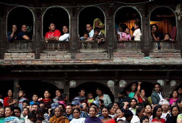Bhaktapur, Nepal: People look at men pulling ropes to bring down a pole during the celebration of the traditional Nepali New Year