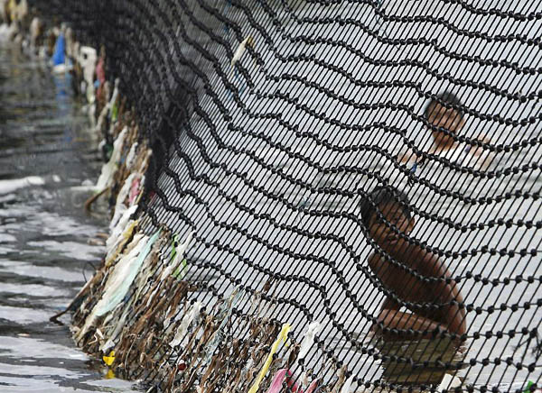 Manila, Philippines: Youngsters swim along the polluted shorelines of Manila bay