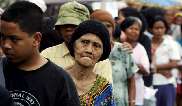 Poor people queue in a line to get a free one kilo bag of rice in Indonesia