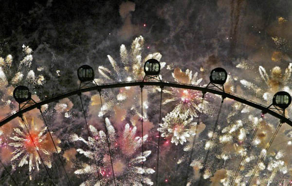 Singapore: Capsules are silhouetted against fireworks released at the grand opening ceremony of the world's largest observation wheel