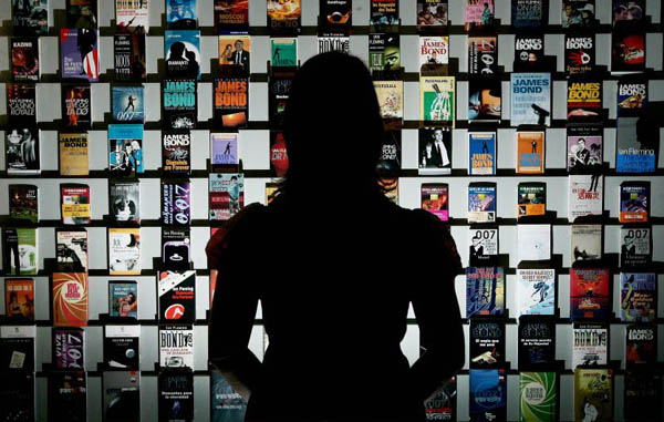 London, UK: A lady looks at a collection of Ian Fleming James Bond 007 books at the 'For Your Eyes Only: Ian Fleming & James Bond Press View' at the Imperial War Museum