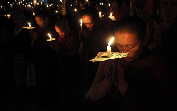 Dharmsala, India: An exile Tibetan prays during a candlelit vigil