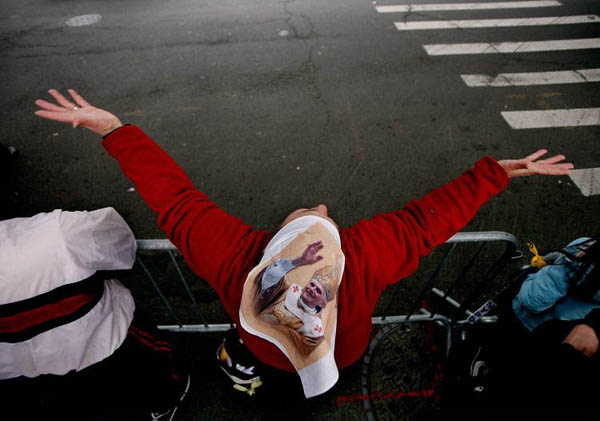 New York, US: Rosa Rodriguez wears a flag depicting Pope Benedict XVI while singing and praying across the street from Yankee stadium