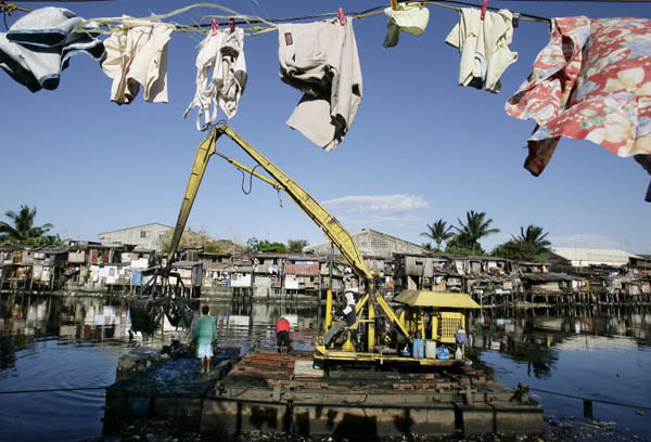 Manila, Philippines: A crane collects domestic waste during the declogging of the Paranaque river