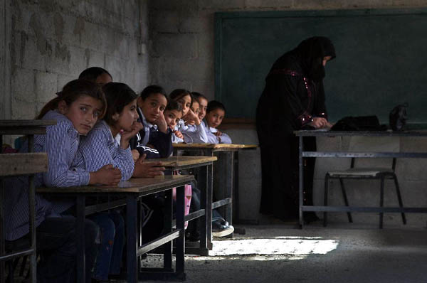 Yatta, West Bank: Palestinian schoolgirls wait in their classroom for the vitamin-enriched snacks provided daily by the World Food Program