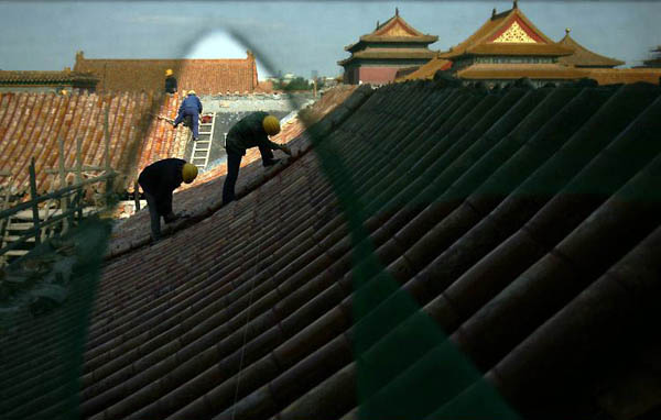 Beijing, China: Workers repair tiles on the roof of Cining Palace in the Forbidden City