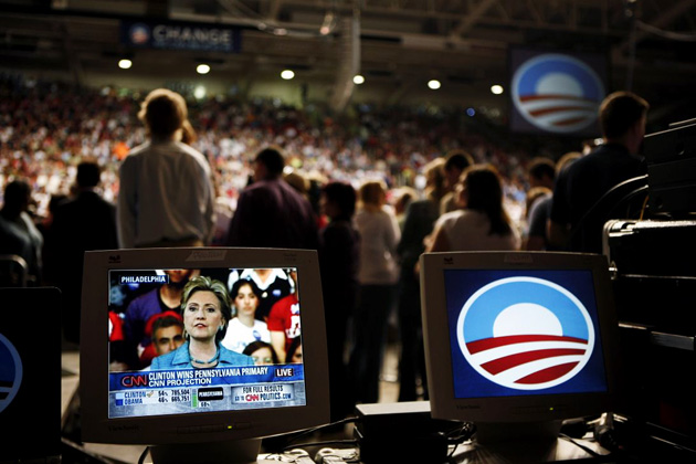 Hillary Clinton is seen on a small screen making her victory speech in Pennsylvania, while Barack Obama addresses his supporters in Indiana
