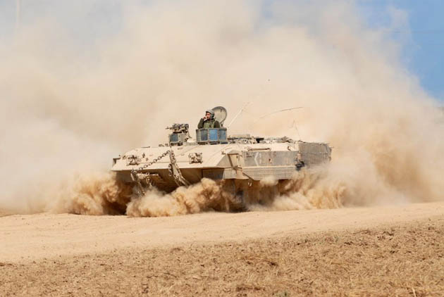 An Israeli armoured personnel carrier rolls out of the Gaza Strip into Israel near the Kisufim crossing
