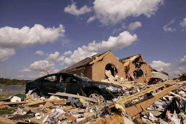 A smashed car sits in a pile of debris