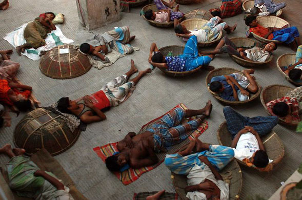 Dhaka, Bangladesh: Porters take a nap while working at Kawran Bazaar