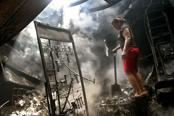 Managua, Nicaragua: A woman stands on the wreckage of her burned local shop after a fire at the Oriental market