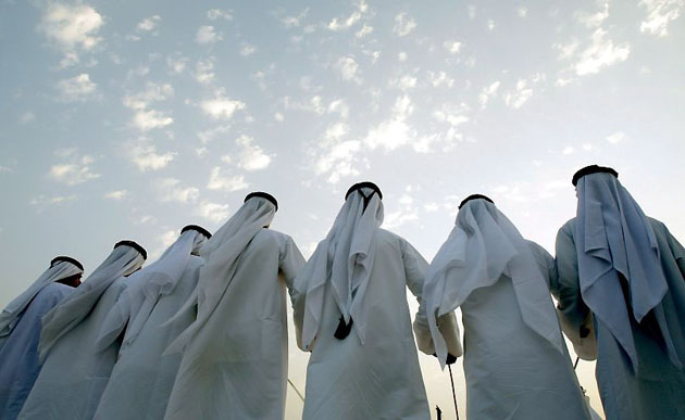 Liwa, United Arab Emirates: Men perform a traditional dance during a mass wedding