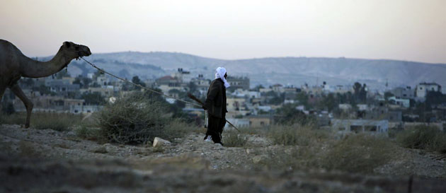 Jericho, West Bank: A walks with his camel close to an Israeli army checkpoint