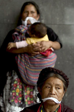 Guatemala City, Guatemala: Women gag their mouths as a part of a protest against the murder of the indigenous leader Francisco Tepeu
