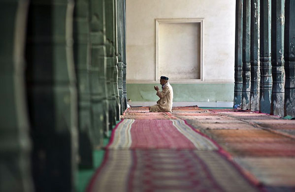 Xinjiang province, China: A Uighur Muslim worshiper prays inside the Kashgar Idgah mosque