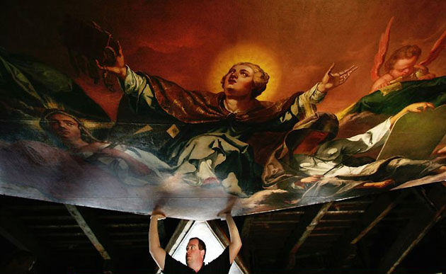 Oxford, UK: A worker assists in the installation of the largest panel of the restored ceiling at the Sheldonian Theatre