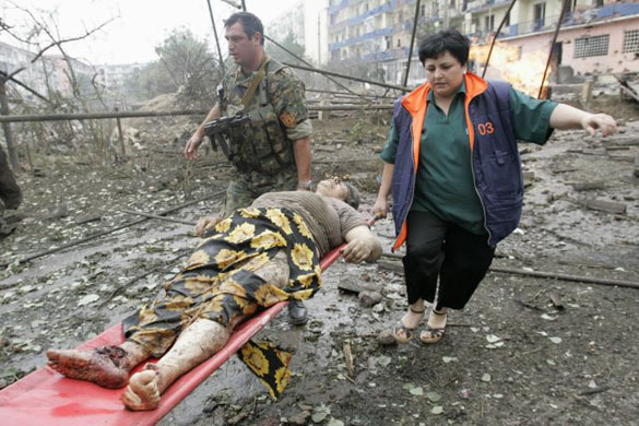 Georgians help an injured woman in the town of Gori