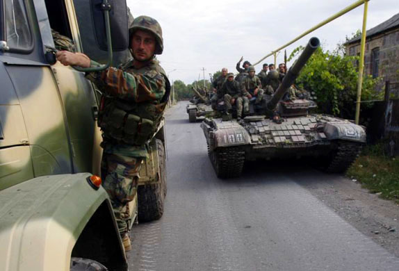 Georgian soldiers sit on a tank near the border with South Ossetia 
