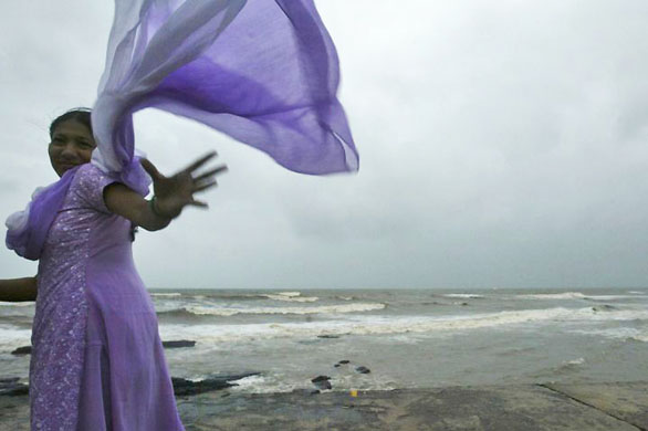 Mumbai, India: A woman tries to catch her scarf as it flies in the wind