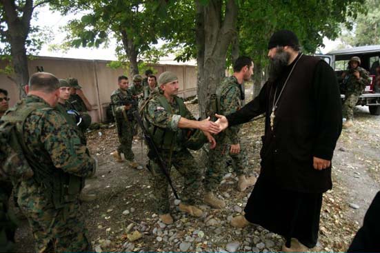 A priest greets Georgian soldiers
