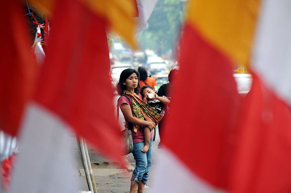 akarta, Indonesia: A woman cradling a child signals to offer 'jockey' service
