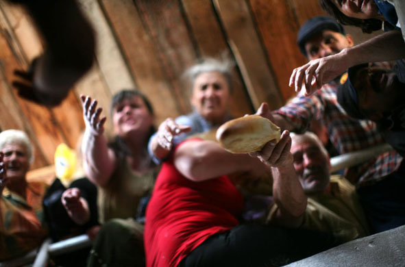 Gori, Georgia: Locals reach for loaves of bread at a bakery 