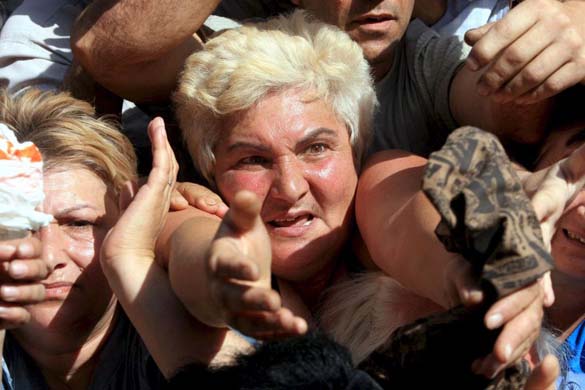 Residents reach out for humanitarian aid distributed from a bus in Gori