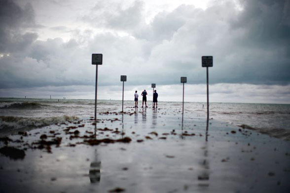 Key West, US: Residents stand at the end of a pier during a lull in tropical storm Fay