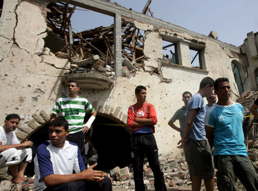 Boumerdes, Algeria: Young men stand in front of a house destroyed in a car bomb attack at the National Gendarmerie school
