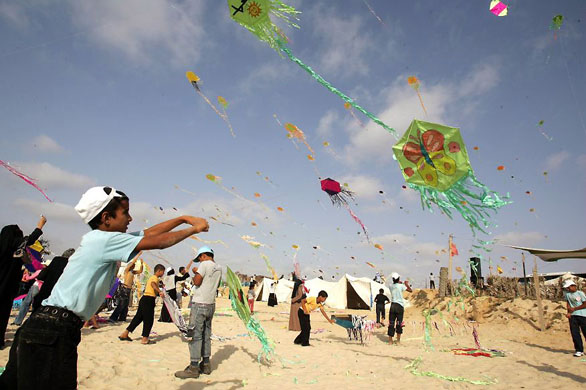 Khan Yunis, Gaza Strip: Children fly kites during a summer camp activity sponsored by the United Nations Relief and Works Agency