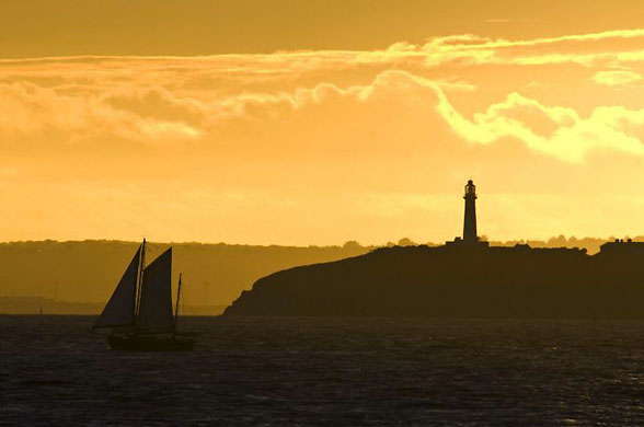 Bristol Channel, UK: The sun sets over Flatholme lighthouse situated in the between Weston-super-Mare and Cardiff