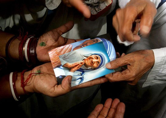 Calcutta, India: Sister Nirmala, Mother Teresa's successor distributes Mother Teresa's photos during mass prayer session