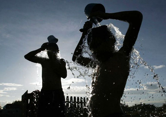 Maros district, Indonesia: Boys bathe near a water barrel