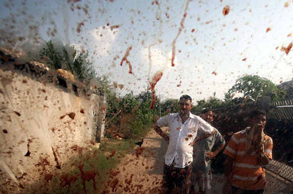 Chinor, India: Onlookers are seen through the windshield of an auto-load carrier stained with the blood of its driver killed by militants