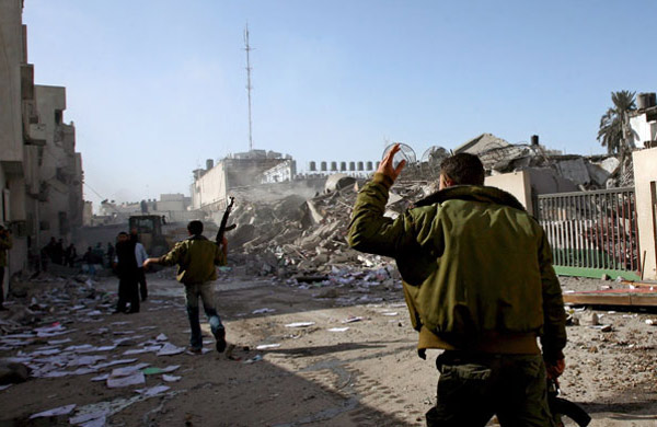 Palestinian Hamas security guards inspect the scene after an Israeli missile attack in the streets of Gaza City