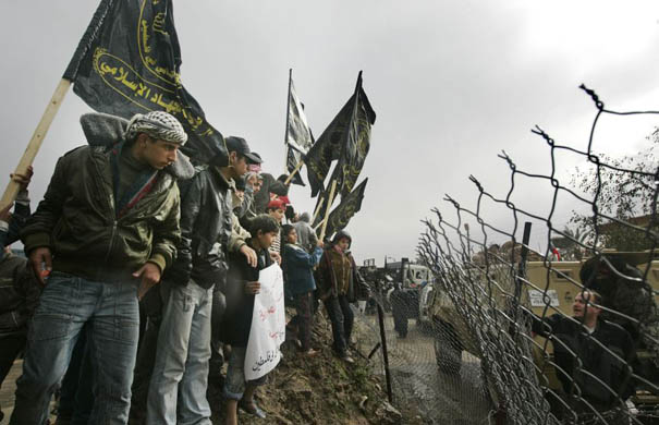 Palestinians stand on the Egypt-Gaza border during an Islamic Jihad demonstration