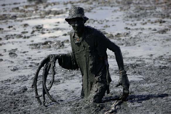 A reveller walks in mud at the Bloco da lama samba carnival in Parati, Brazil