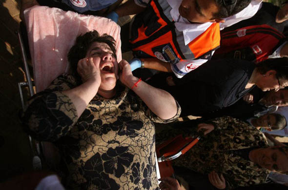 Sderot, Israel: A woman cries out as she is taken away by paramedics after a rocket attack