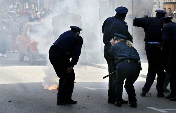 Police take cover while clashing with Bosnian Serb protestors