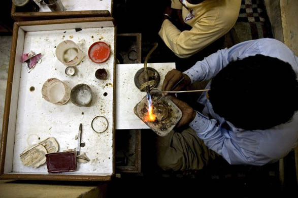 Amritsar city, India: A jeweller at work in a shop in the local gold market