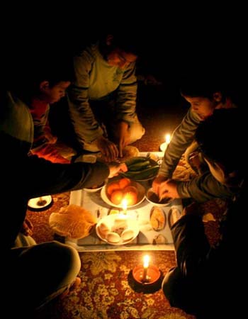 A family in Gaza eats by candlelight