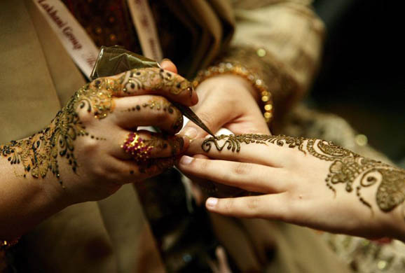 A women gets her hand henna painted in a exhibitors stand at the Asian Bride Show 2008