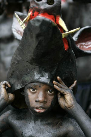 A boy wears a mask during a carnival parade