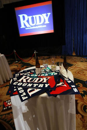 Posters and discarded drinks sit on a table after Rudy Giuliani talked to supporters