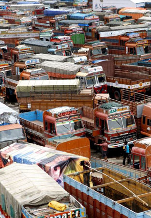 Mumbai, India: An attendant mends a truck at a terminal during a strike to protest an increase in fuel taxes