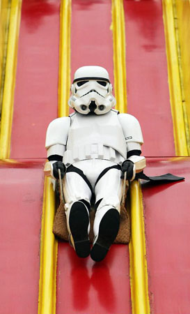 London, UK: A Storm Trooper rides a giant slide at 'The Amazing Great Children's Party' in Battersea Park