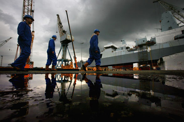 Glasgow, UK: Workers walk past a type 45, the destroyer being built in Govan shipyard